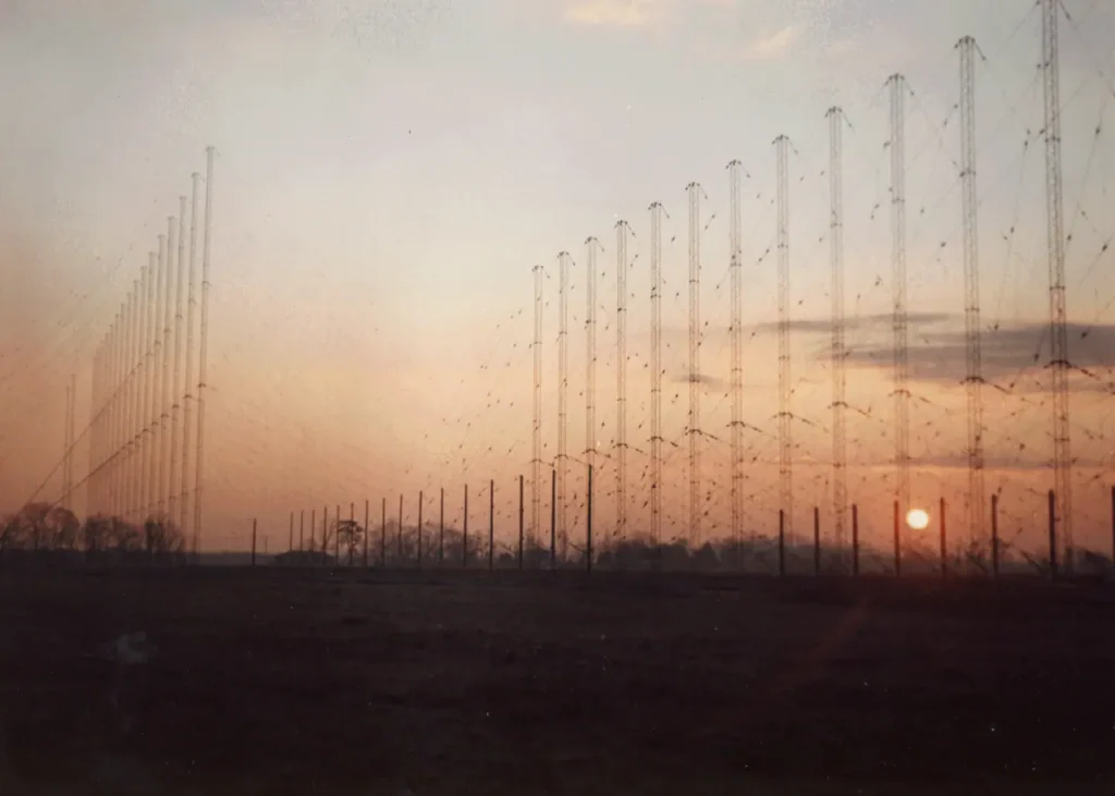 Fila de torres y antenas de una estación de radar transhorizonte ROTHR instalada en un campo abierto durante el amanecer.