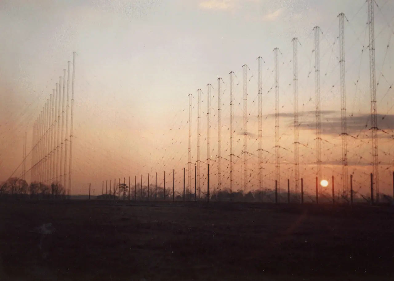 Fila de torres y antenas de una estación de radar transhorizonte ROTHR instalada en un campo abierto durante el amanecer.