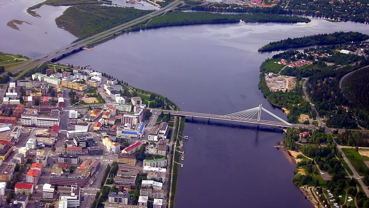 Vista aérea de Rovaniemi, capital de la Laponia finlandesa, atravesada por el río Kemijoki y con un puente al fondo.