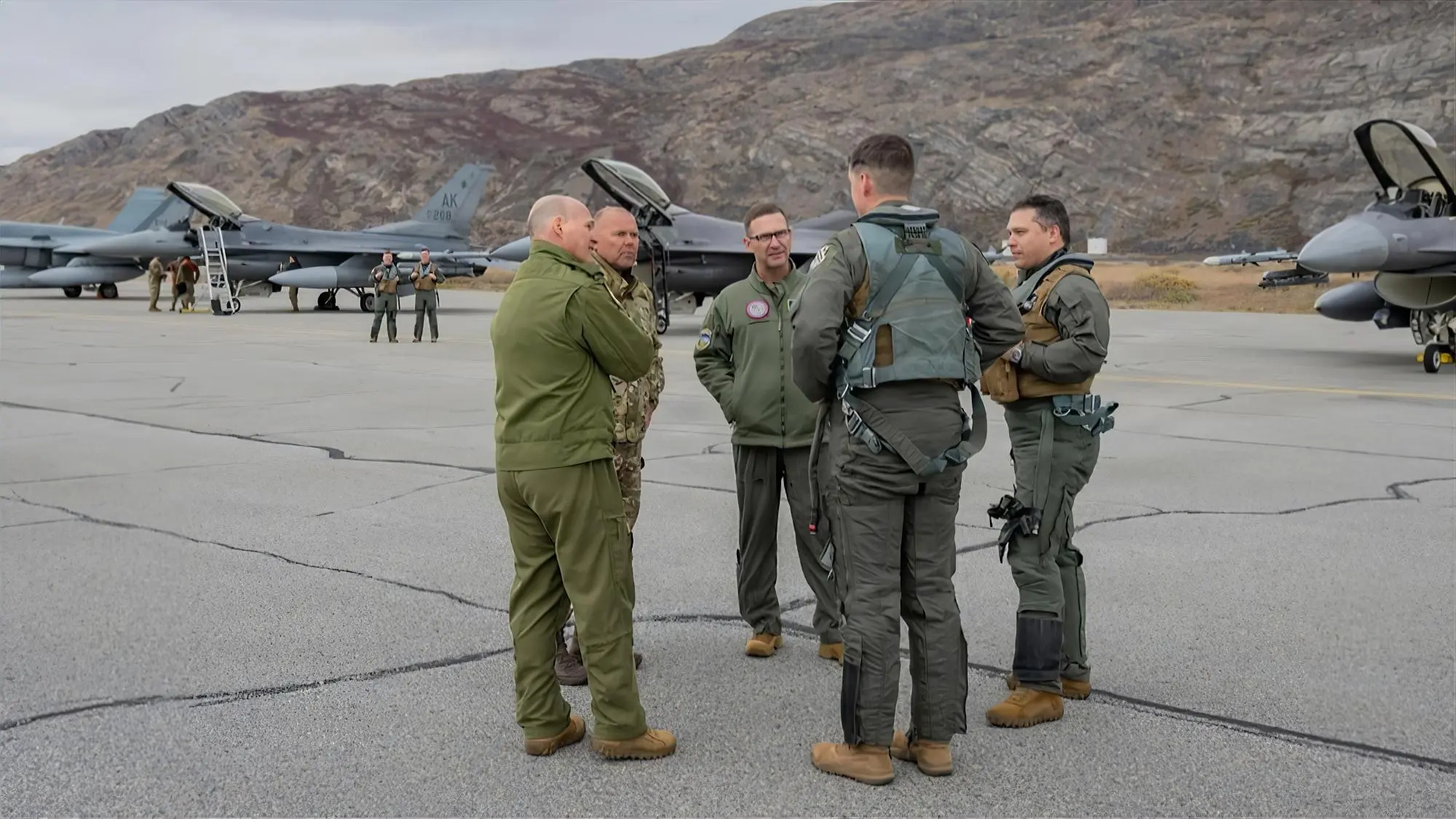 Líderes militares de Estados Unidos, Dinamarca y Canadá conversan junto a cazas F-16 en la pista de Kangerlussuaq, Groenlandia, durante la Operación Arctic Vanguard.